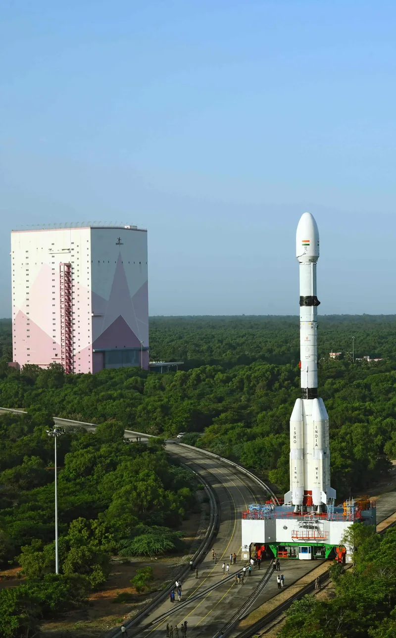 श्रीहरिकोटा में प्रक्षेपण से पहले GSLV-F17 रॉकेट, पीछे असेंबली भवन और हरियाली।